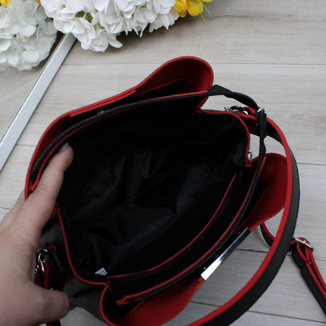 Жіноча чорна сумка з червоними акцентами зі шкірозамінника