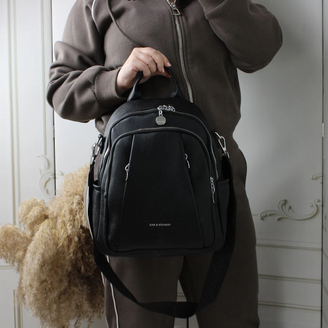 Жіноча чорна сумка-рюкзак з екошкіри з текстильним ременем та срібною фурнітурою