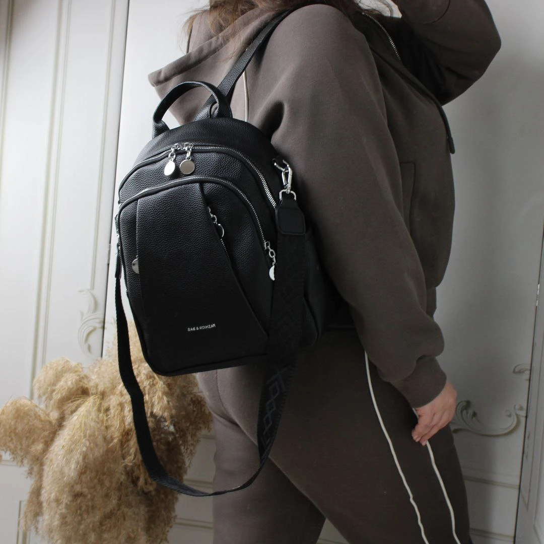 Жіноча чорна сумка-рюкзак з екошкіри з текстильним ременем та срібною фурнітурою