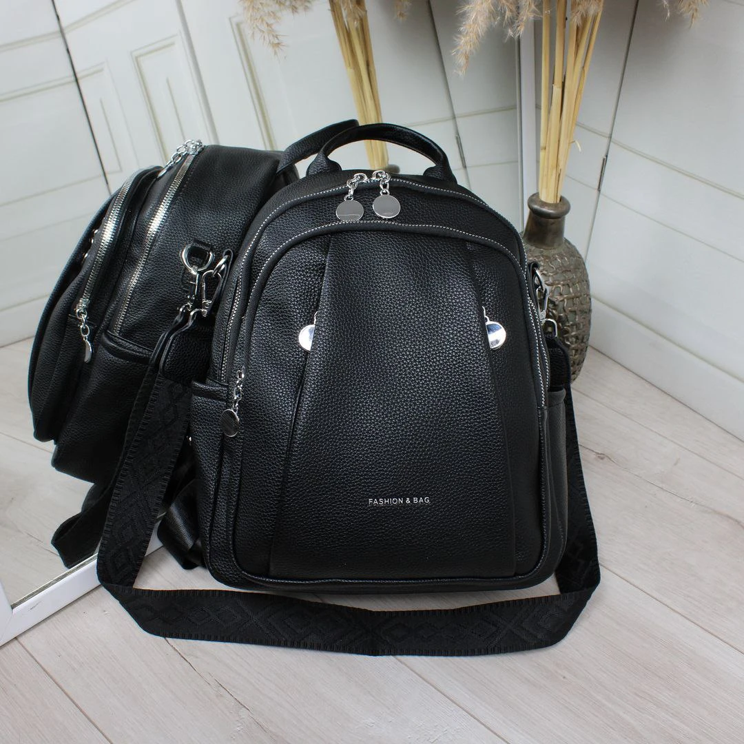 Жіноча чорна сумка-рюкзак з екошкіри з текстильним ременем та срібною фурнітурою