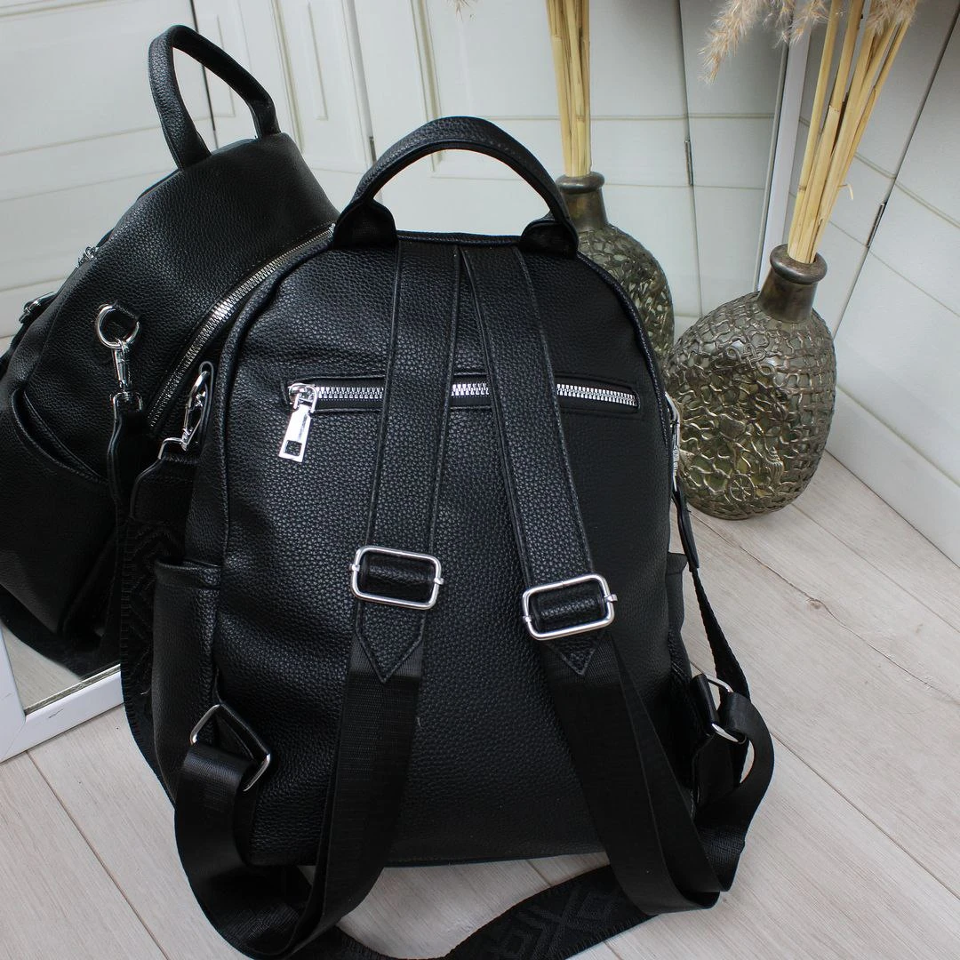 Жіноча чорна сумка-рюкзак з екошкіри з текстильним ременем та срібною фурнітурою