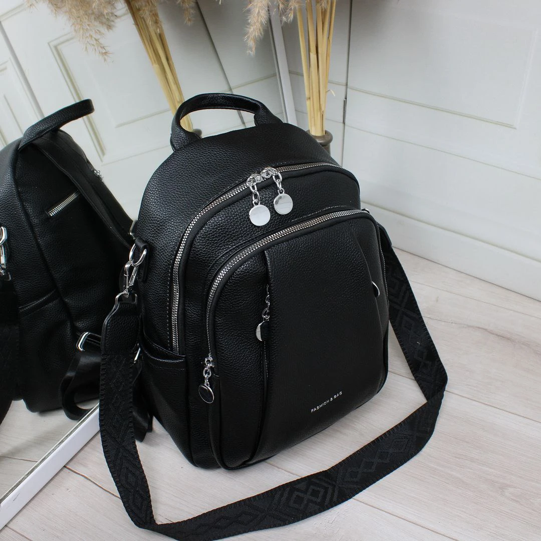 Жіноча чорна сумка-рюкзак з екошкіри з текстильним ременем та срібною фурнітурою